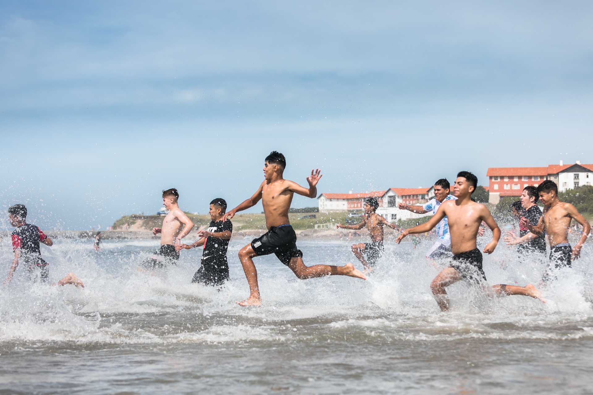 Un grupo de chicos corre hacia el agua después de un entrenamiento de fútbol en la playa. En estas costas, en estas aguas, muchos argentinos y argentinas conocieron el mar por primera vez. ESTRELLA HERRERA