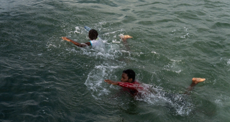 Niños locales nadando junto al puerto de Juanchaco. MT