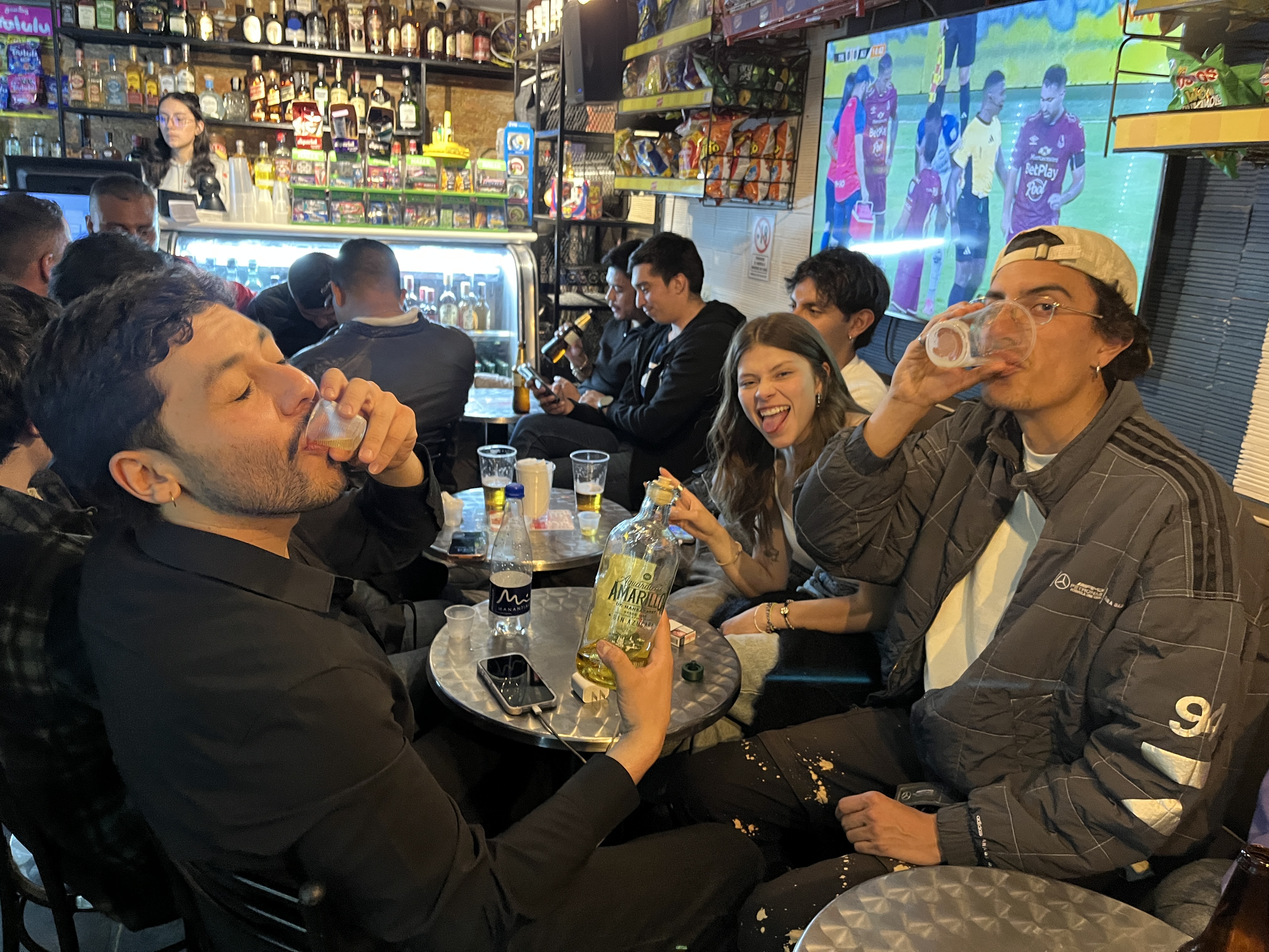 Valeria Bernal, junto a un grupo de amigos, comparten una ronda de guaro en una taberna de Bogotá. H.E.