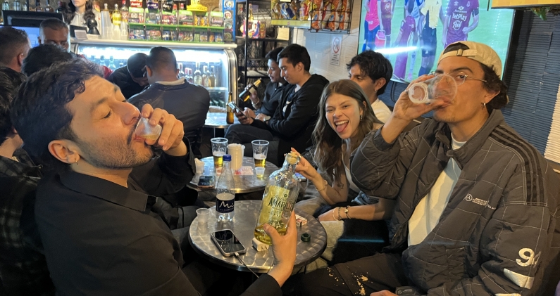 Valeria Bernal, junto a un grupo de amigos, comparten una ronda de guaro en una taberna de Bogotá. H.E.