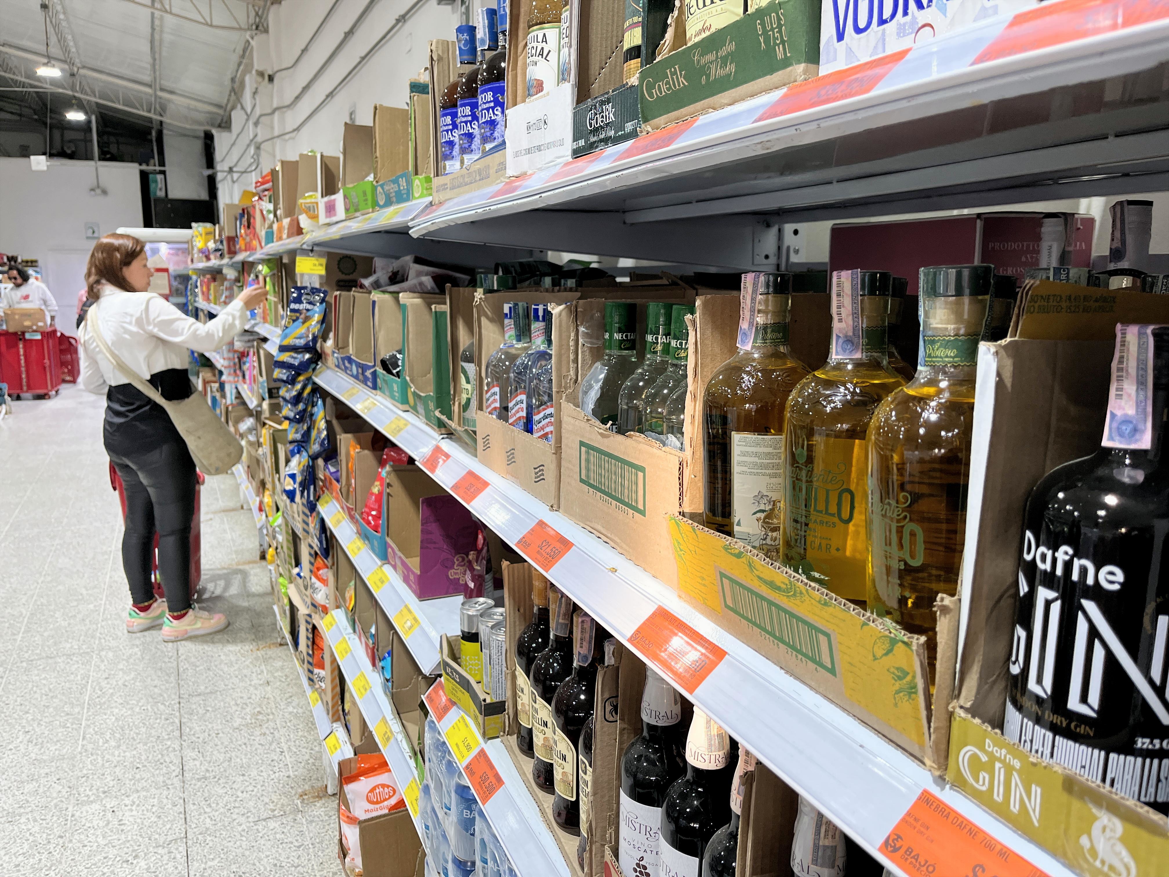 Aguardientes de distintas regiones comparten estantería en un supermercado, una escena impensable durante años. H.E.