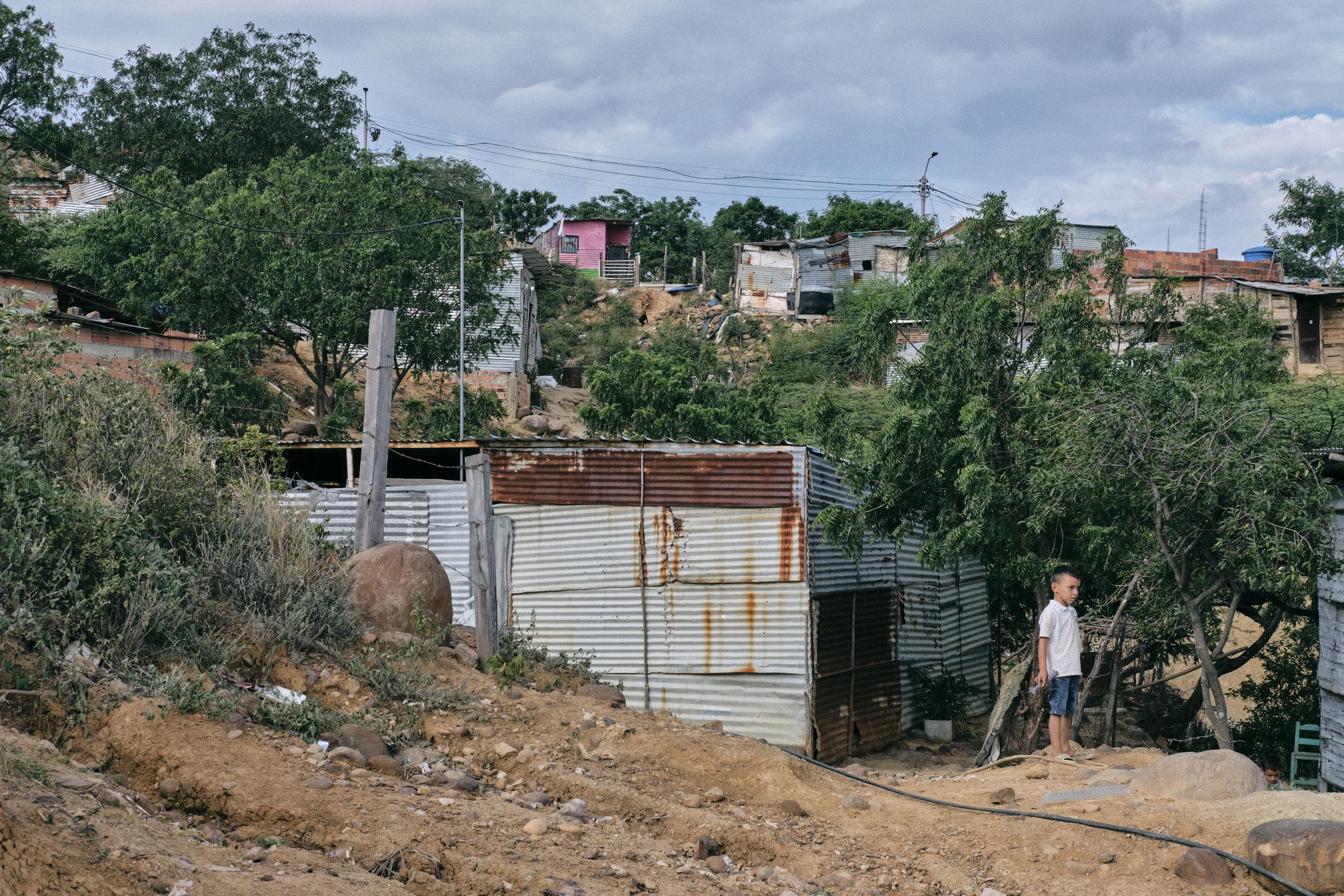 Un niño habitante de La Esperanza observa el barrio desde la parte alta. MTQ