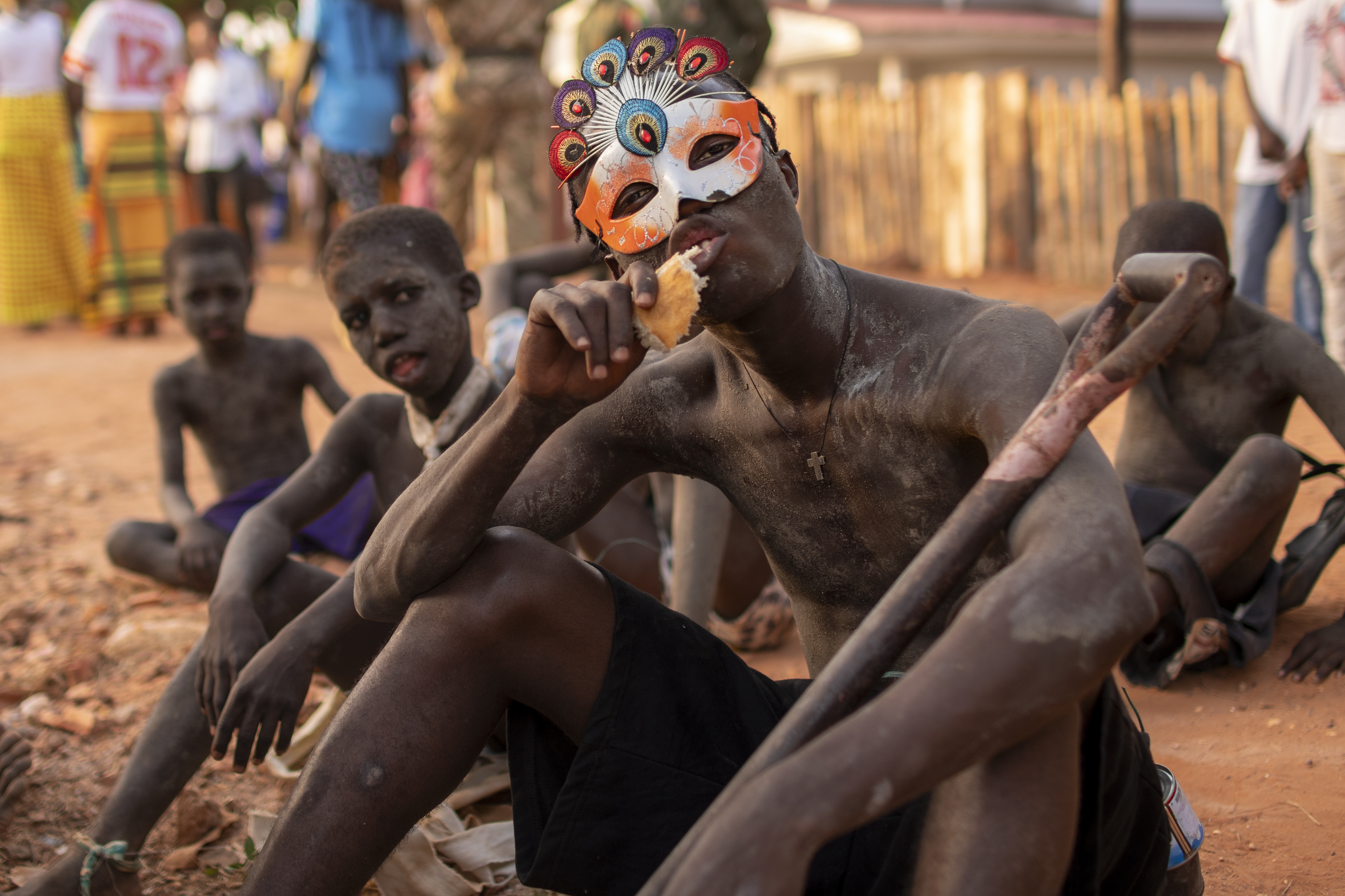 Un grupo de jóvenes comen y descansan entre baile y baile. La mayoría de las ceremonias guineanas son sincréticas y es frecuente el uso de elementos tradicionales y modernos, así como combinaciones de símbolos de diferentes religiones. JORGE FORNIELES