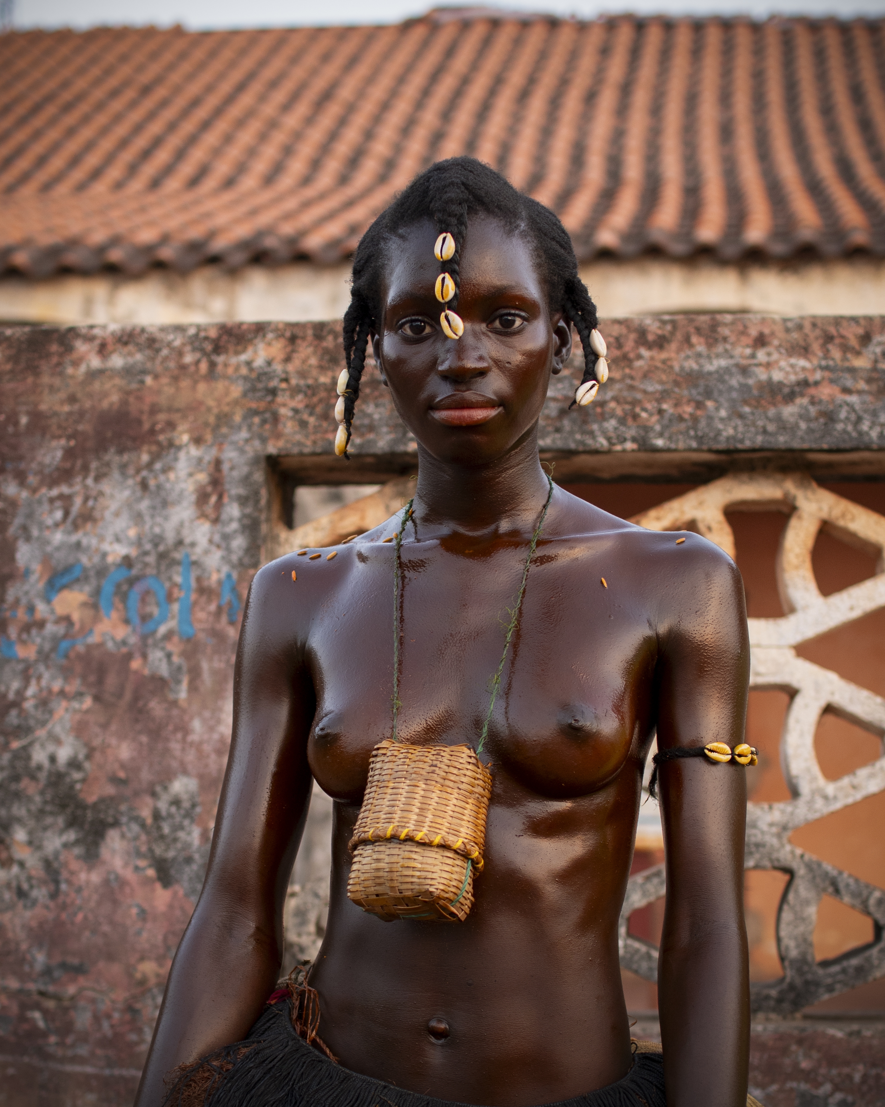 Raquele, líder de su agrupación, viste una saya de fibra vegetal, usa diversos adornos de conchas cauri, y lleva un cesto colgado. Su cuerpo, como el de muchas mujeres, está embadurnado en aceite de palma. JORGE FORNIELES