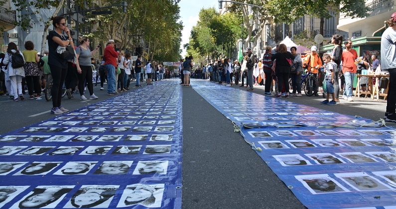 Filas de rostros de desaparecidos recorren la marcha del 24 de marzo de 2019 en Buenos Aires. DEFENSORÍA DEL PUEBLO
