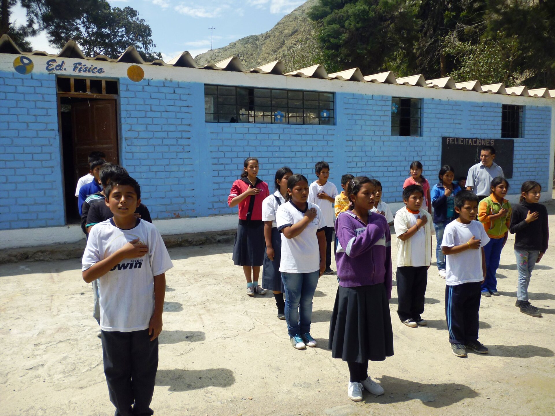 Estudiantes entonan el himno nacional en el patio de una escuela en Perú. ESCUELA DE NIVÍN