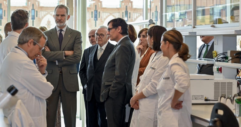 S. M. el Rey, Isidro Fainé y Salvador Illa escuchando a los investigadores del CaixaResearch Institute. FUNDACIÓN "LA CAIXA"