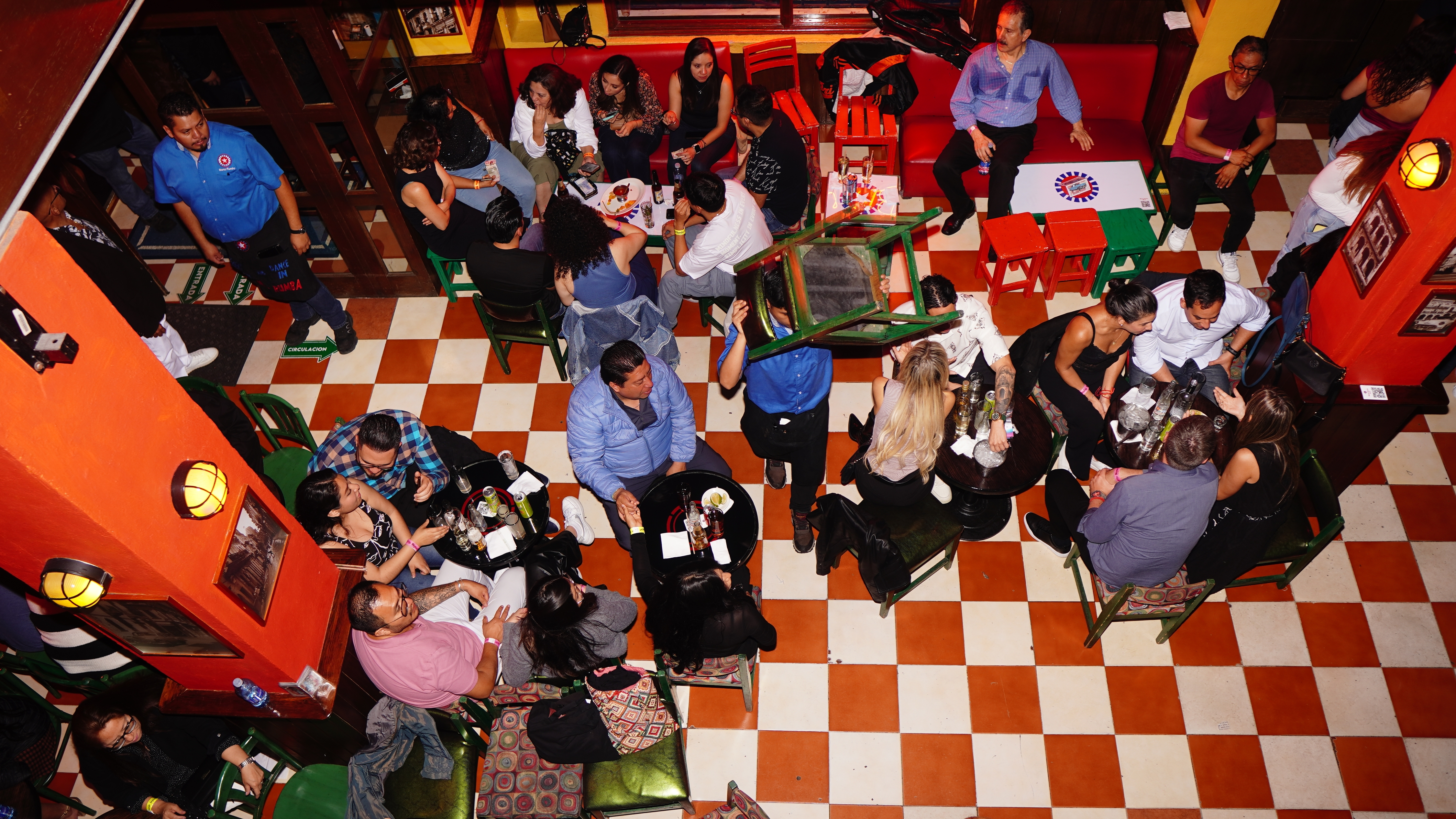 Clientes conversan en el interior de Mamá Rumba, uno de los locales salseros más emblemáticos de Ciudad de México. DIEGO TORRES PANTÍN