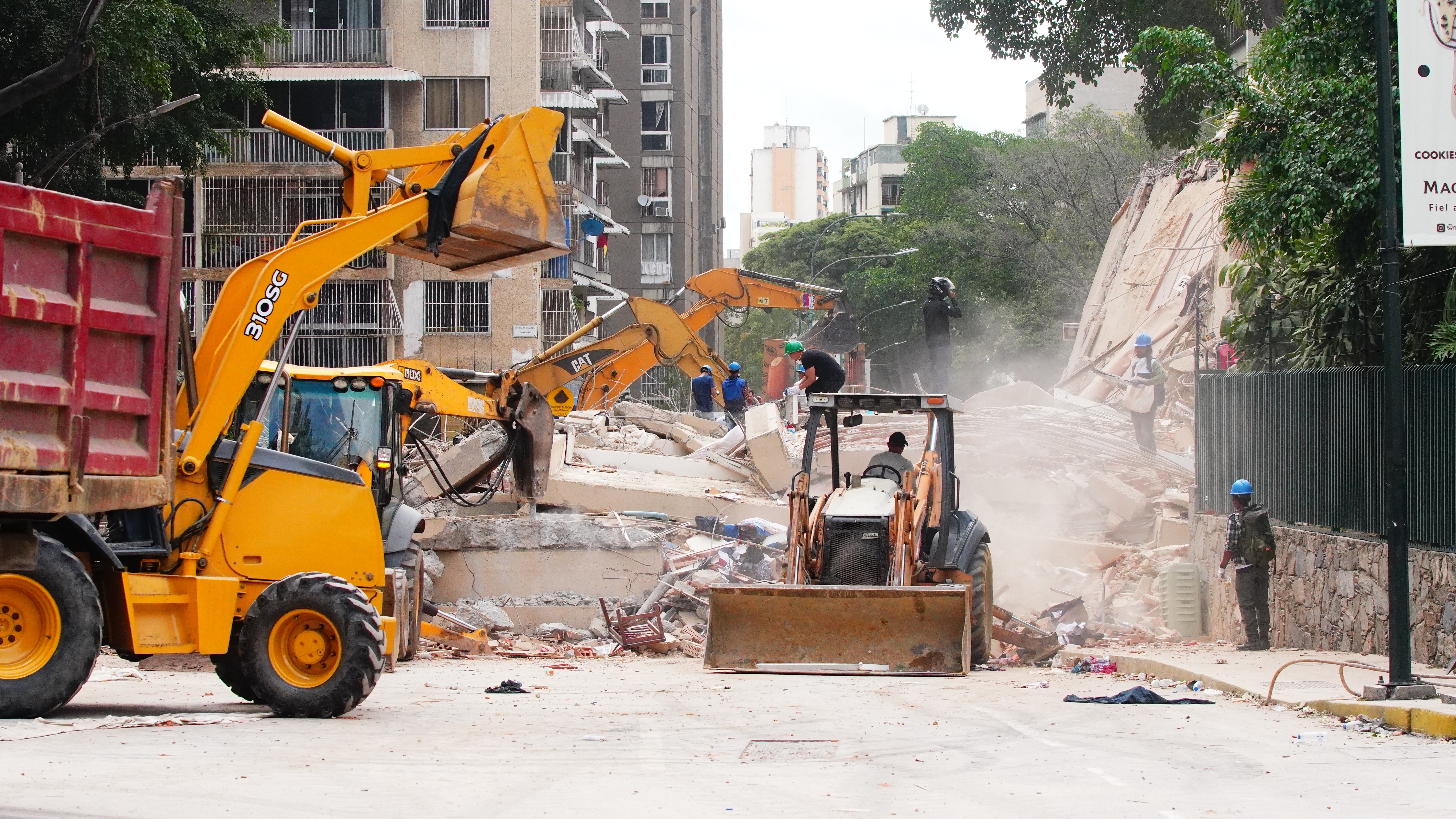 Autoridades usan maquinaria pesada para remover escombros en una cuadra de Los Palos Grandes donde se derrumbaron dos edificios. DTP