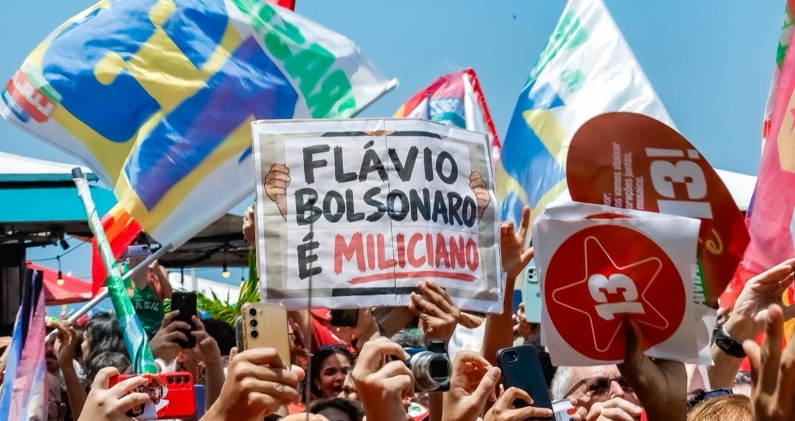 Una pancarta contra Flávio Bolsonaro durante un acto de campaña de Lula en Río de Janeiro. RICARDO STUCKERT Una pancarta contra Flávio Bolsonaro durante un acto de campaña de Lula en Río de Janeiro. RICARDO STUCKERT