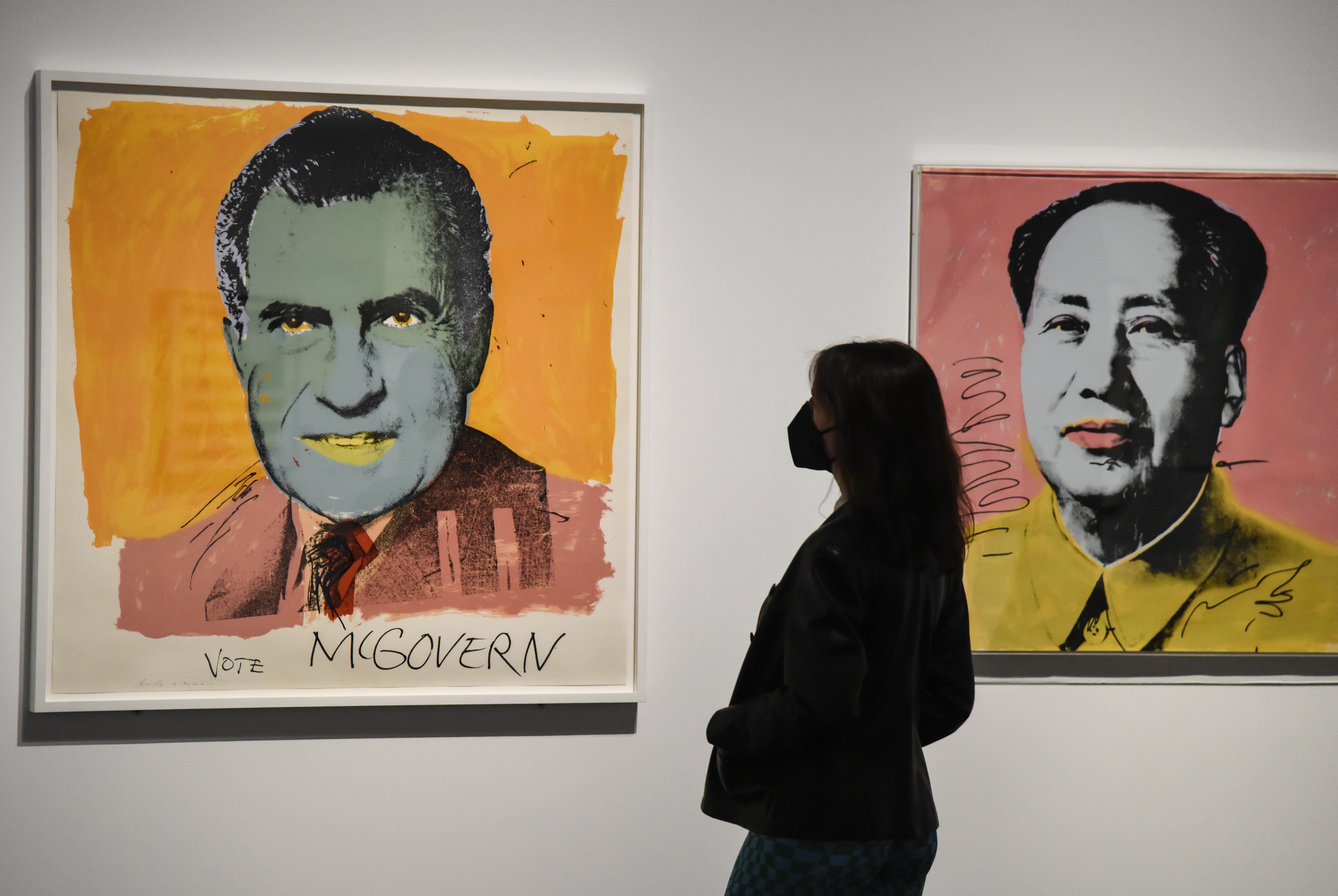 Una visitante de la exposición 'El sueño americano', ante las obras 'Vote McGovern' y 'Mao', de Andy Warhol. FUNDACIÓN "LA CAIXA"