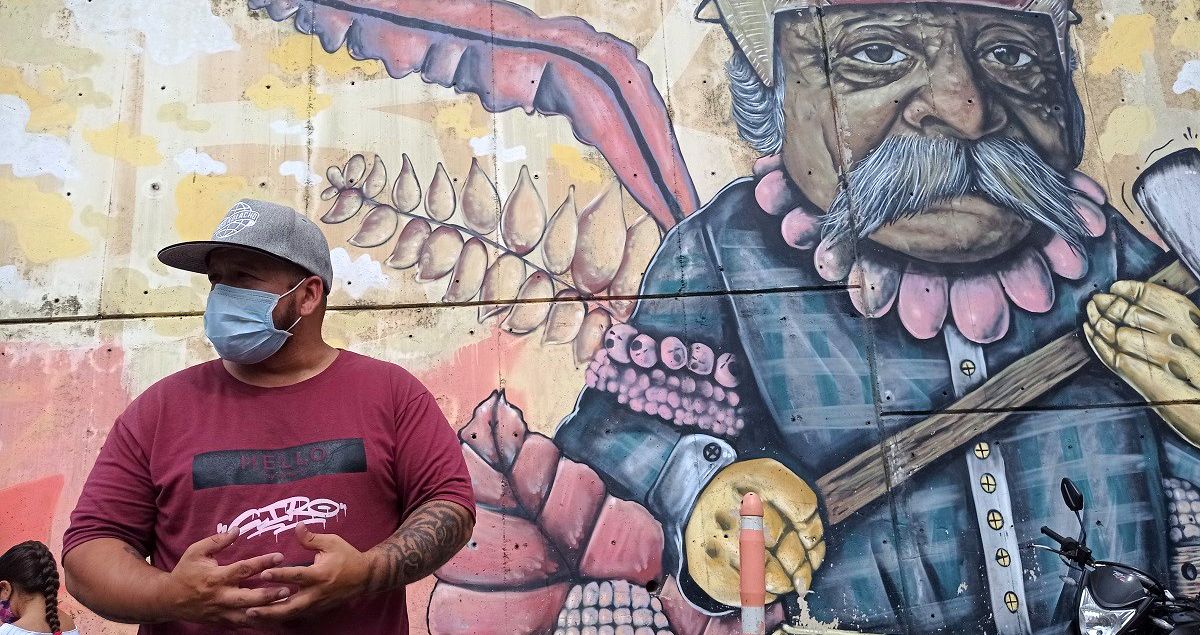 Ciro, guía del Graffitour, frente a uno de los murales de la Comuna 13, en Medellín. JOHANNA OSORIO