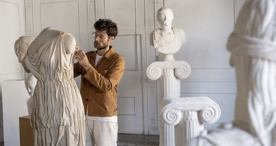 El artista Sergio Roger, tejiendo una de sus esculturas de estilo grecorromano, en su estudio de Barcelona. CORTESÍA