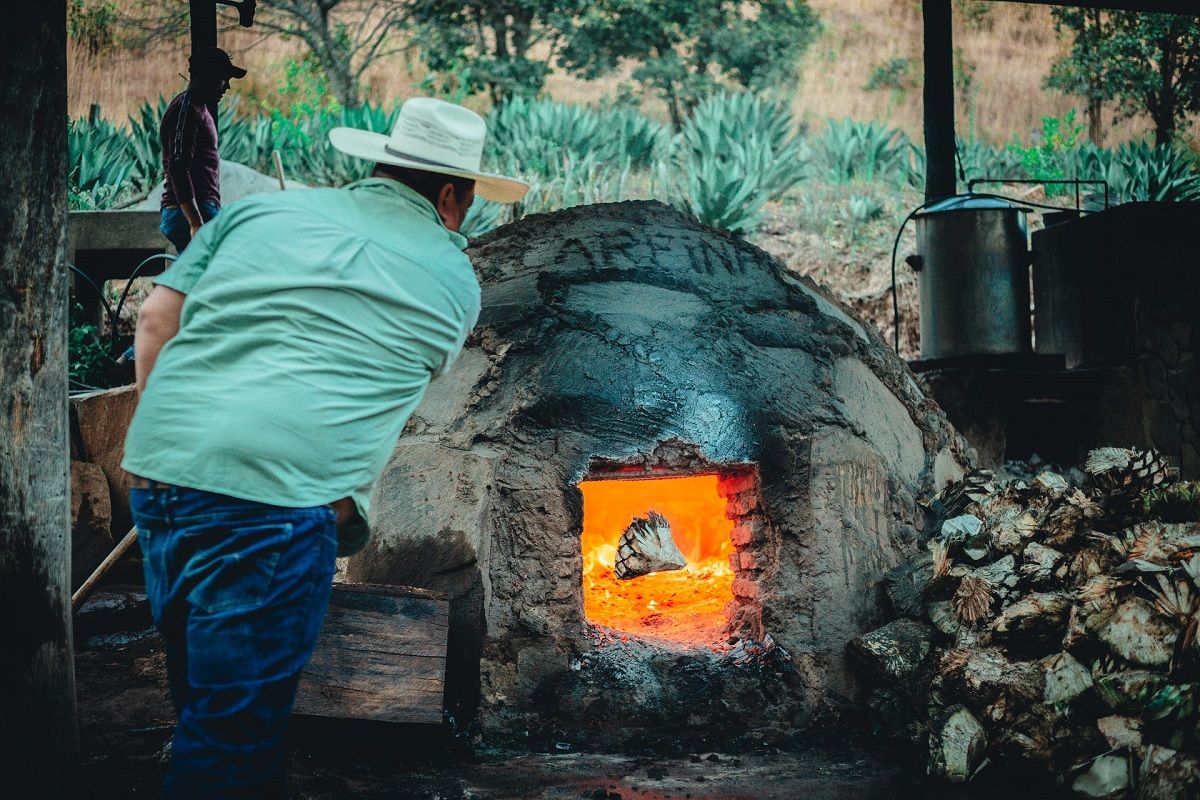 Un campesino quema piñas de agave para producir mezcal en Jalisco. UNSPLASH/MARY WEST