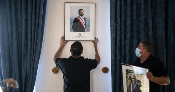 Un empleado del Palacio de La Moneda de Chile coloca el retrato del presidente Gabriel Boric, el rostro de la nueva izquierda en América Latina. PRESIDENCIA DE CHILE