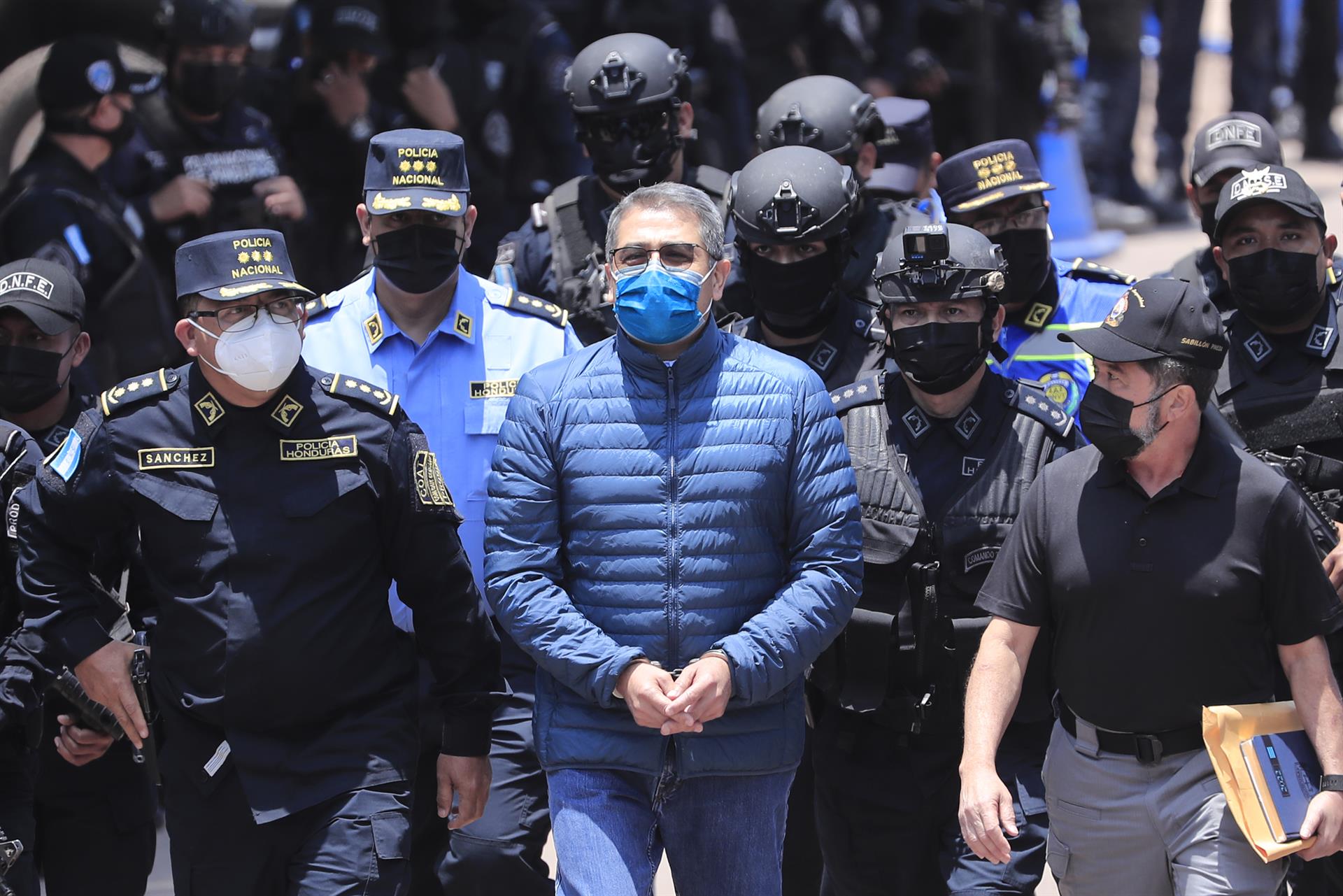 Policías custodian al expresidente de Honduras Juan Orlando Hernández durante su extradición a Estados Unidos, este jueves, en Tegucigalpa. EFE/GUSTAVO AMADOR