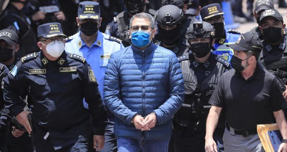 Policías custodian al expresidente de Honduras Juan Orlando Hernández durante su extradición a Estados Unidos, este jueves, en Tegucigalpa. EFE/GUSTAVO AMADOR