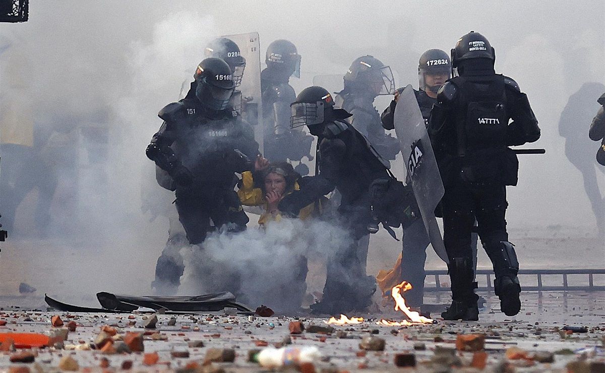 Policías detienen a una manifestante en una protesta en recuerdo del estallido social de 2021, en la Universidad Nacional de Bogotá, Colombia, el 28 de abril de 2022. EFE/MAURICIO DUEÑAS