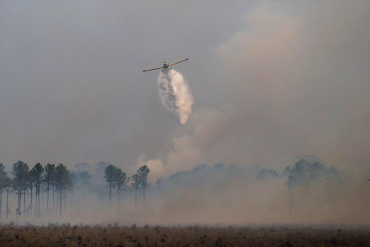 Una avioneta lanza agua sobre un incendio en Santo Tomé, Argentina, el 22 de febrero de 2022. EFE/JUAN IGNACIO RONCORONI