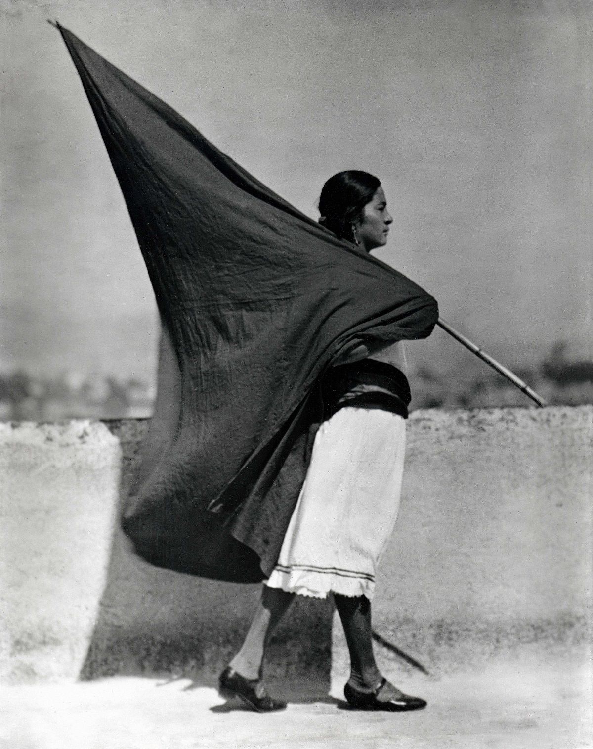 Mujer con bandera, c. 1928, Ciudad de México. © TINA MODOTTI/CORTESÍA: GALERIE BILDERWELT, REINHARD SCHULTZ