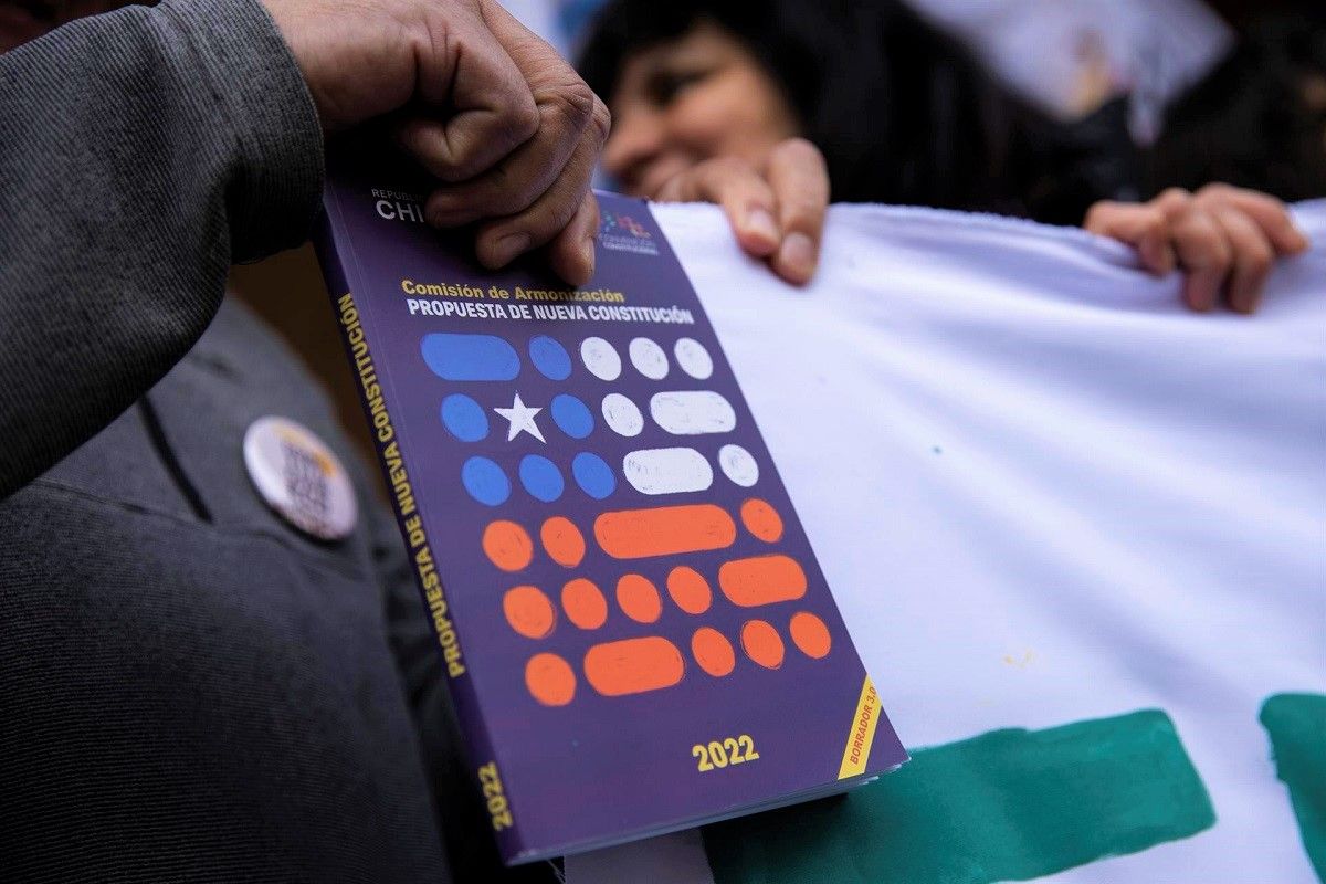 Un hombre sostiene un ejemplar de la propuesta de nueva Constitución de Chile, en Santiago, el 24 de agosto de 2022. EFE/ALBERTO VALDÉS