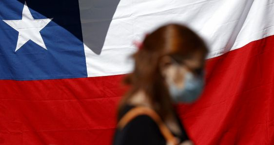 Una mujer frente a una bandera chilena tras el plebiscito constitucional, en Santiago de Chile, el 5 de septiembre. EFE/ALBERTO VALDÉS