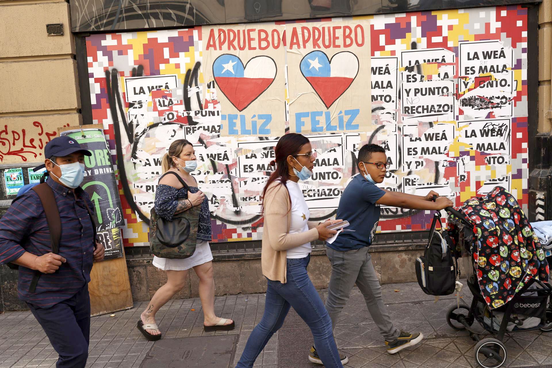 Personas caminan frente a carteles del plebiscito constitucional, en Santiago de Chile, el 5 de septiembre de 2022. EFE/ALBERTO VALDÉS