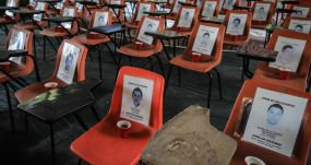 Escritorios con fotos de los 43 desaparecidos del caso Ayotzinapa, en Tixtla, México, el 20 de septiembre de 2022. EFE/DAVID GUZMÁN