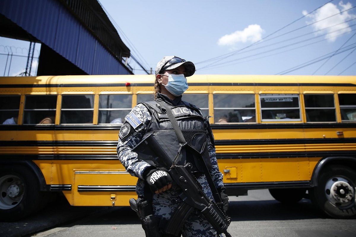 Una agente de policía custodia un autocar con detenidos en San Salvador, el 26 de abril de 2022. EFE/RODRIGUO SURA 4