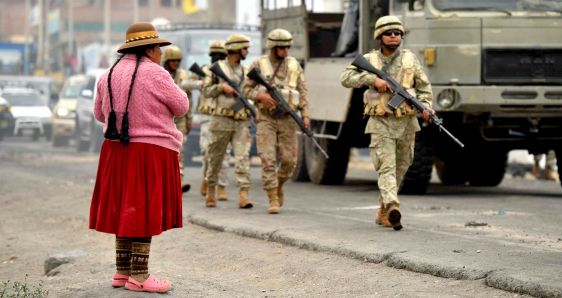 Una mujer observa a militares desplegándose por las calles de Arequipa, Perú, el 15 de diciembre, en plena crisis del país. EFE/JOSÉ SOTOMAYOR
