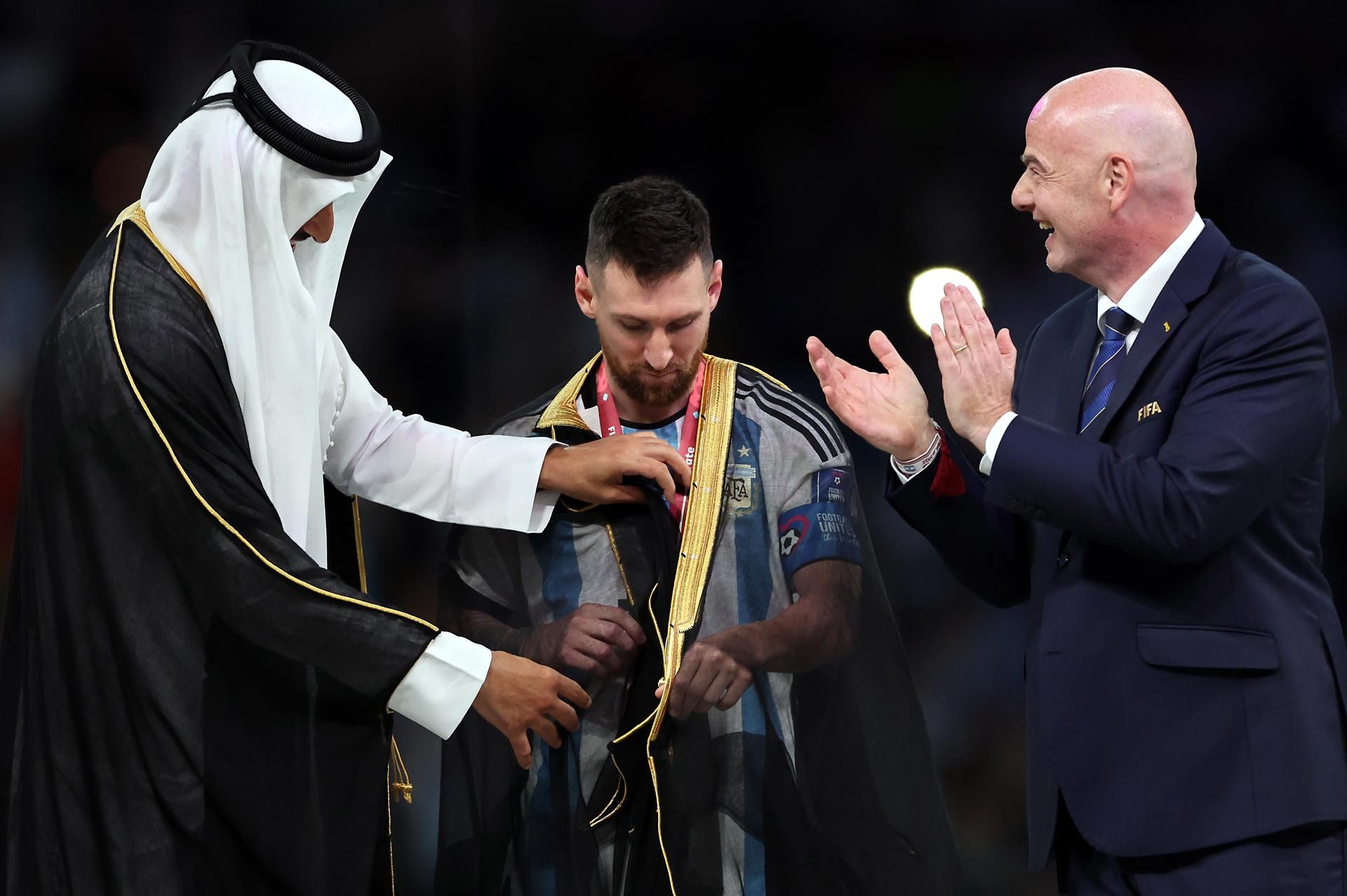 El emir de Qatar, Tamim bin Hamad Al Thani, coloca a Leo Messi el 'bisht' ante Gianni Infantino tras ganar el Mundial. EFE/EPA/TOLGA BOZOGLU