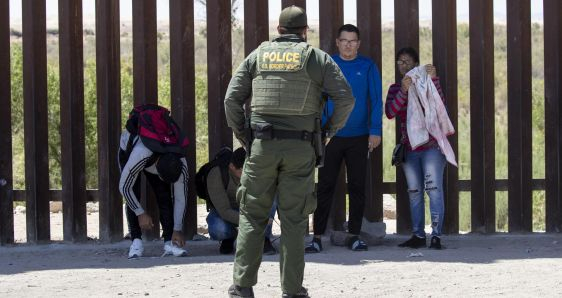 Un patrullero en la frontera entre México y Estados Unidos con unas personas migrantes. EFE/ETIENNE LAURENT