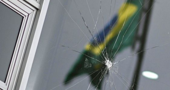 La bandera de Brasil, reflejada en los cristales rotos del Palacio del Planalto, en Brasilia, el 9 de enero. EFE/ANDRE BORGES