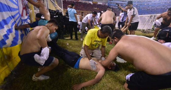 Asistentes al estadio Cuscatláán de San Salvador auxilian a un herido tras la estampida, este 20 de mayo de 2023. EFE/MIGUEL LEMUS