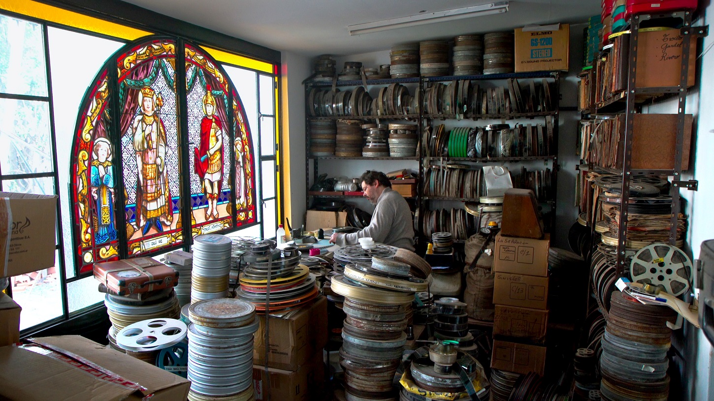El archivista argentino Fernando Martín Peña, rodeado de latas de filme, en el documental 'La vida a oscuras'. ALINA FILMS/ALAMBRADO CINE