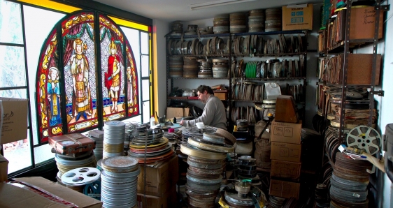 El archivista argentino Fernando Martín Peña, rodeado de latas de filme, en el documental 'La vida a oscuras'. ALINA FILMS/ALAMBRADO CINE