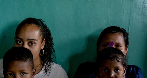 Rugelita (derecha), firmante de la paz que vive amenazada en Colombia, con sus dos hijos y su escolta, Valentina. MARIO TORO QUINTERO