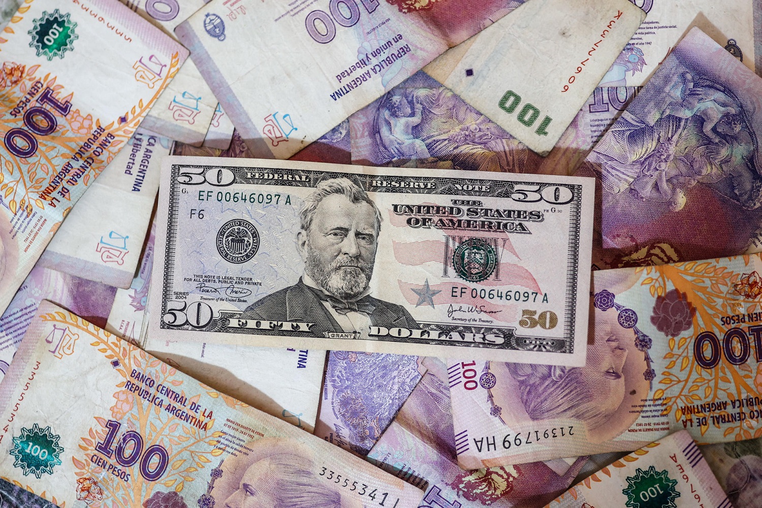 Billetes de dólares y de pesos argentinos en Buenos Aires. EFE/JUAN IGNACIO RONCORONI