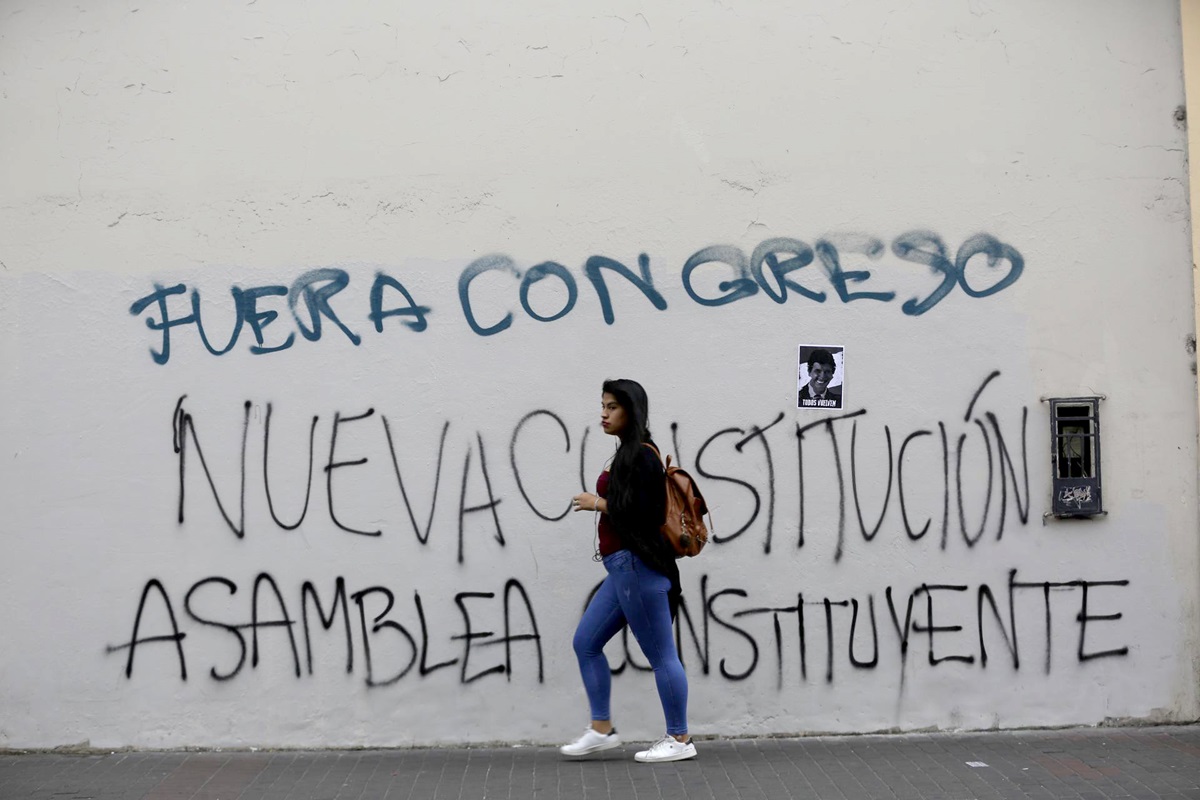 Una mujer frente a una pintada contra el Congreso en Lima, Perú, 16 de diciembre de 2022. EFE/BIENVENIDO VELASCO