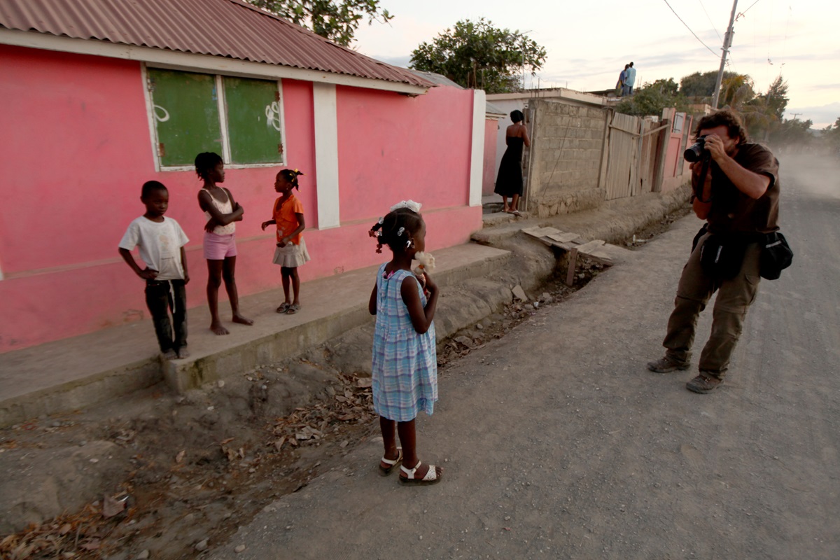 El fotógrafo argentino Rodrigo Abd, retratando a una niña en Haití, en 2011. NICOLÁS GARCÍA