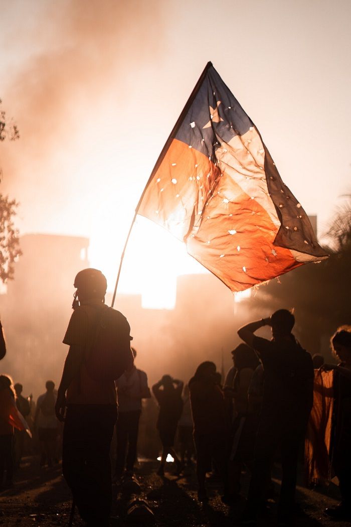 Un manifestante con la bandera chilena, en una protesta en Santiago el 13 noviembre de 2019. UNSPLASH/CRISTIAN CASTILLO