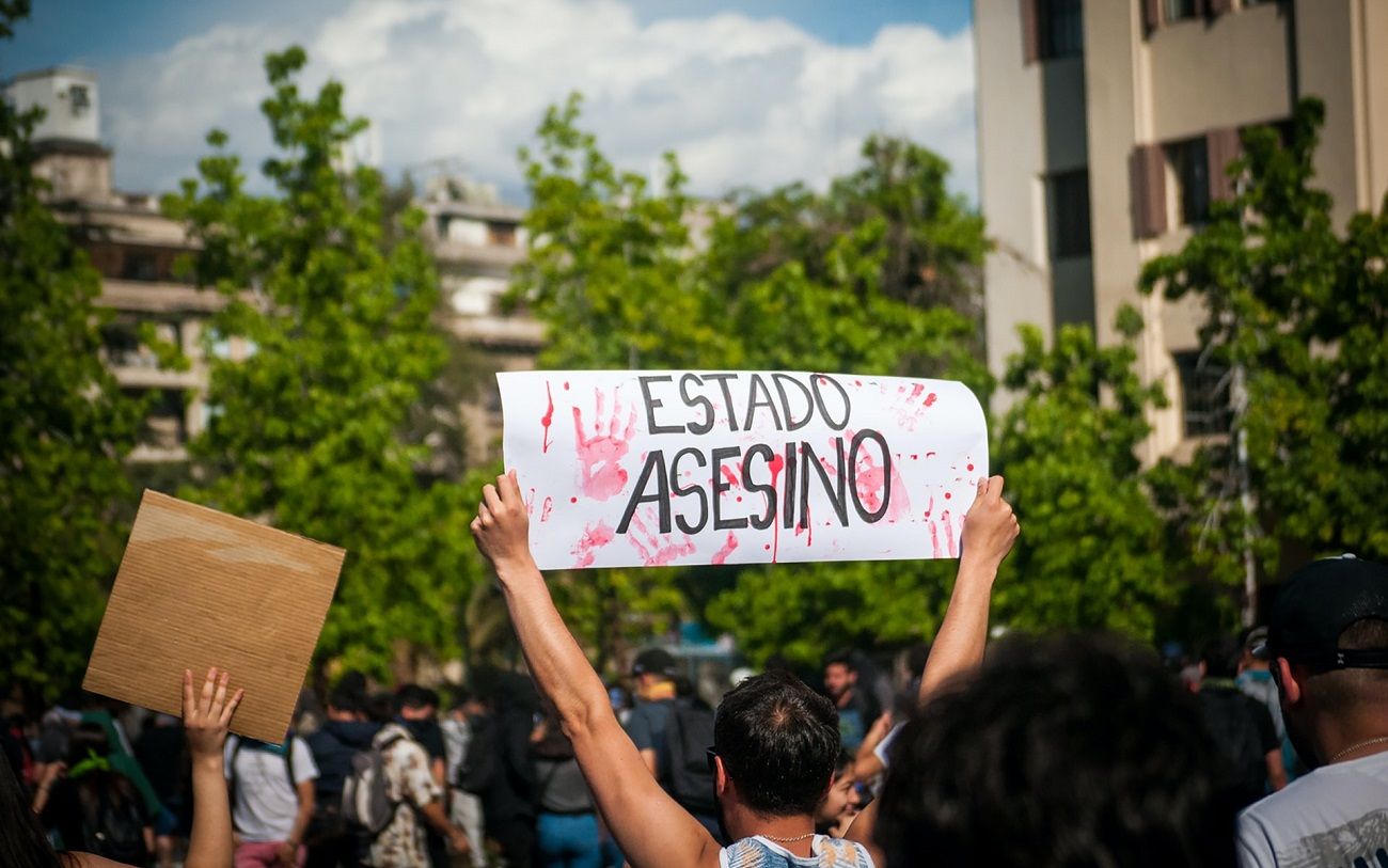 Un manifestante portando un cartel en una protesta en Santiago el 4 diciembre de 2019. UNSPLASH/JUAN MANUEL NÚÑEZ MÉNDEZ
