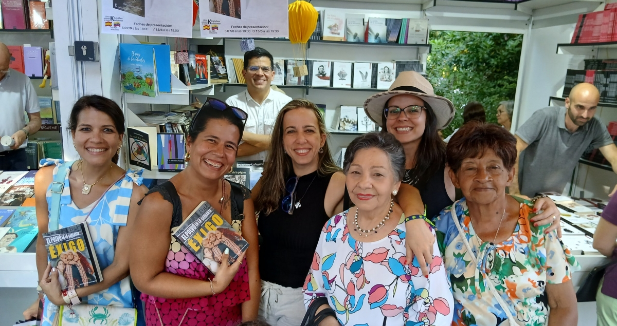 Lectoras venezolanas en la caseta de Kálathos en la Feria Libro de Madrid 2025. Al fondo, el escritor Eduardo Sánchez Rugeles. CORTESÍA